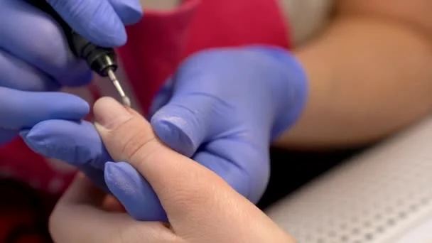 Manicure realizando técnica de cutilagem Russa em sua cliente