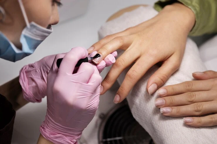 manicure pintando as unhas de sua cliente